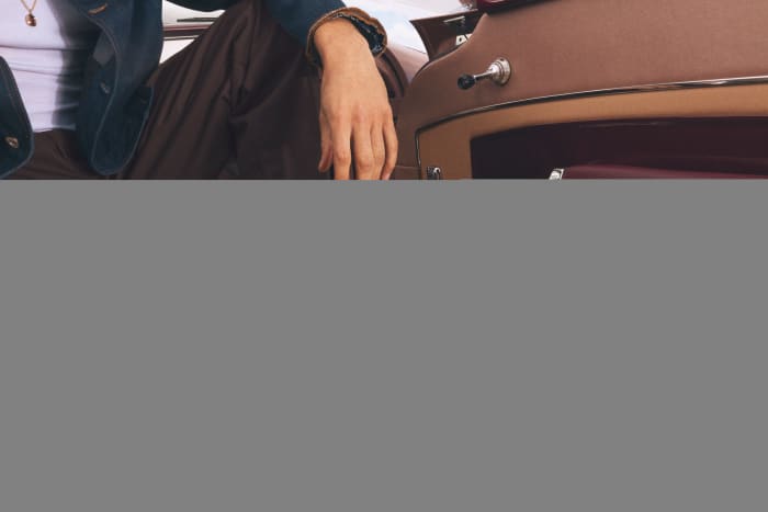 Devin Booker modeling white Converse sneakers.